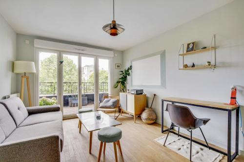 un salon avec un canapé et une table dans l'établissement Le Saint Cyr, à Saint-Cyr-lʼÉcole