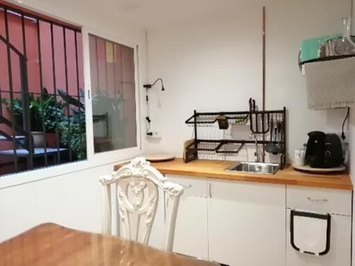 a kitchen with a table and a chair and a window at Mi refugio in Bormujos