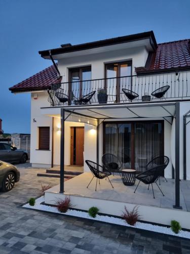 a house with two chairs and a balcony at Villa Złote Noce in Mikołajki