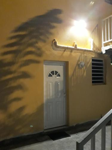 a shadow of a tree on the side of a building at A la montagne in Morne Vert