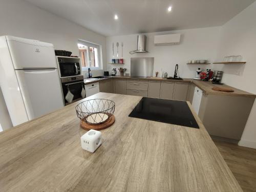 una cucina con tavolo in legno e piano di lavoro di Belle maison rénovée au centre de Agen sacré-cœur a Agen