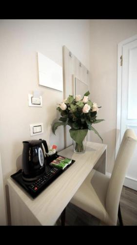 a table with a vase of flowers and a keyboard at FLORENCE ROOMS67 in Florence