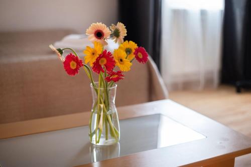 a vase filled with flowers sitting on a table at Avanti apgyvendinimas-restoranas in Biržai