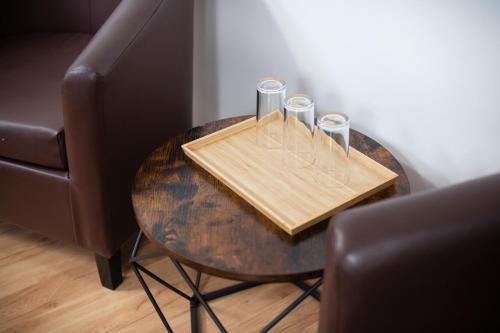 a table with glasses on it next to a chair at Avanti apgyvendinimas-restoranas in Biržai