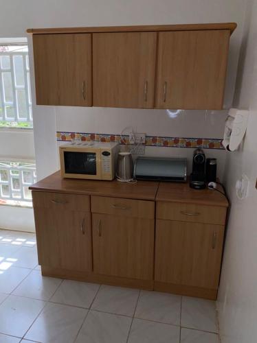 a kitchen with a microwave on top of a counter at Swiss Garden House in Kerr Sering With Full Private Compound in Amdalai