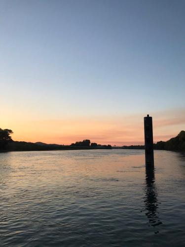 a pole in the water with a sunset in the background at Charmant appartement au cœur de Tarascon in Tarascon