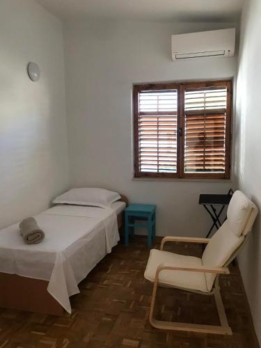 a bedroom with two beds and a chair and a window at Six bedroom Holiday home Matea in Ploče