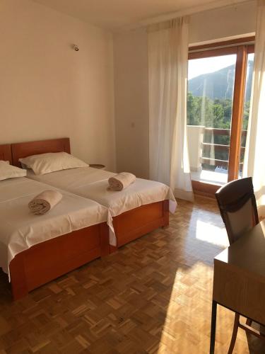 a bedroom with two beds and a table and a window at Six bedroom Holiday home Matea in Ploče
