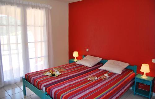 セルベールにあるLe Village Des Aloesの赤い壁のベッドルーム1室