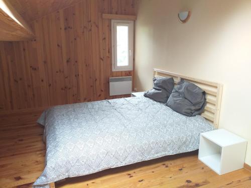 a bedroom with a bed with a blue comforter and a window at Belle maison proche de la ville et du lac in Belcaire
