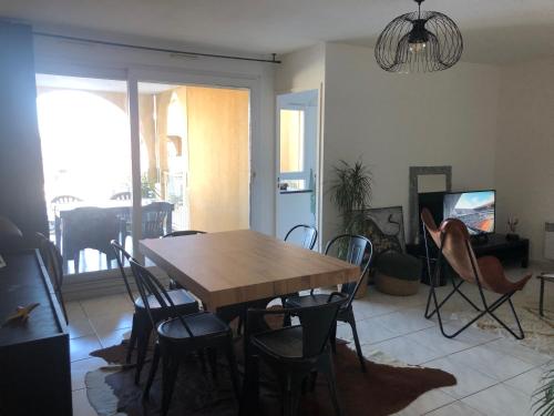 a dining room with a wooden table and chairs at Chambre dans appartement avec vue sur le port in Lattes