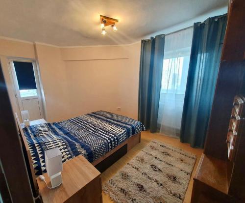 a small bedroom with a bed and a window at Sunrise Apartment in Constanţa