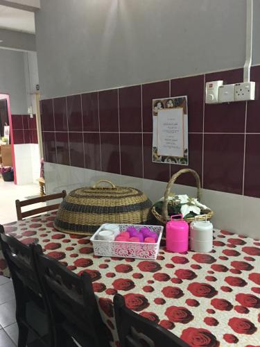 a table with a table cloth with roses on it at Homestay Teratak Saazlina in Seremban