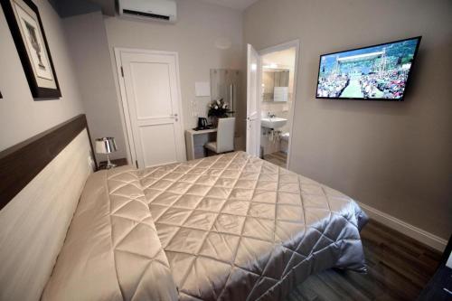 a bedroom with a large bed and a television on the wall at FLORENCE ROOMS67 in Florence