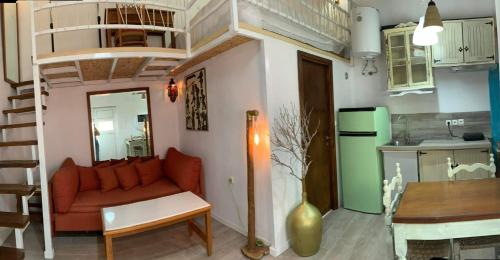 a living room with a couch and a kitchen at Loft Kapodistrias in Corfu Town