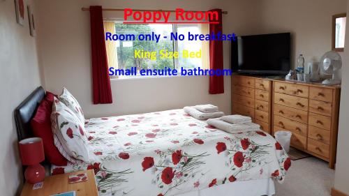 Un dormitorio con una cama con flores rojas. en Pendine Sands Bed & Breakfast, en Pendine
