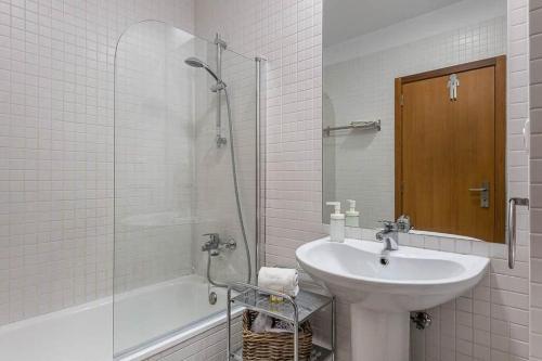 biała łazienka z umywalką i prysznicem w obiekcie Loulé 246 · 1 bedroom apartment · Parking w Porto