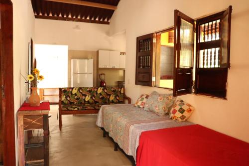 a living room with a bed and a couch at Casa Recanto das Mangueiras Japaratinga - Alagoas in Japaratinga