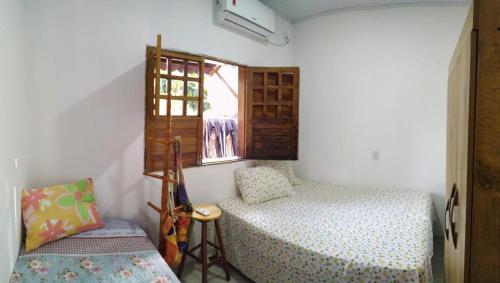 a small bedroom with a bed and a window at Casa Recanto das Mangueiras Japaratinga - Alagoas in Japaratinga