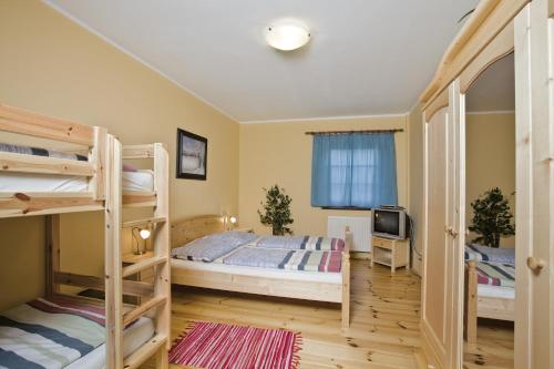 a bedroom with two bunk beds and a television at Wellness Hotel Marlin in Nová Pec