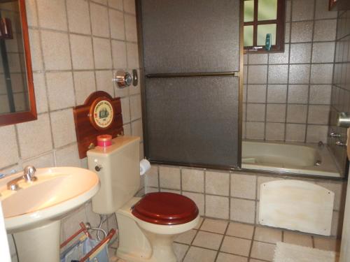 a bathroom with a toilet and a sink and a tub at Casa Ilhabela in Ilhabela