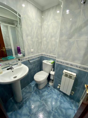 uma casa de banho com um WC branco e um lavatório. em APARTAMENTO CENTRO BURGOS em Burgos