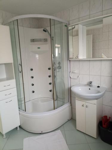 a bathroom with a shower and a sink at Marcell Apartman in Hajdúszoboszló