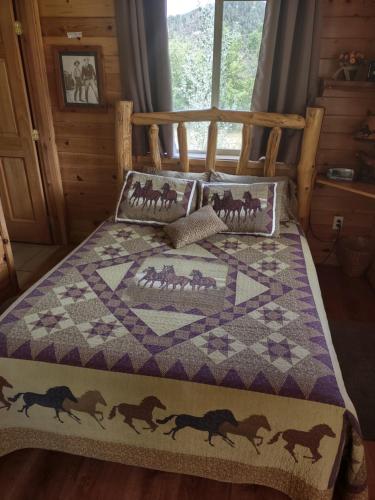 a bed with a quilt with horses on it at The Wandering Star Inn in Glendale