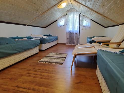 a room with three beds and a wooden floor at Villa Adriana Thassos in Panayia