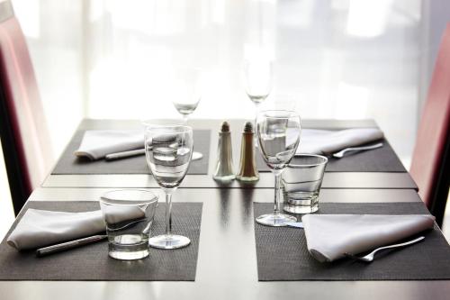 a table with wine glasses and napkins on it at Novotel Belfort Centre Atria in Belfort