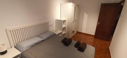 um quarto com uma cama com dois sapatos castanhos em Apartamento Covadonga em Gijón
