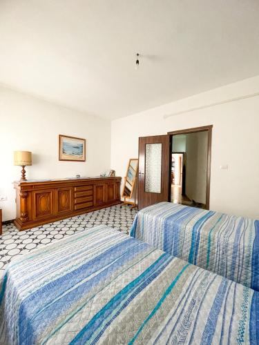 a hotel room with two beds and a dresser at Dommo de Anzelina Central apartment in Dorgali Wi-Fi A/C in Dorgali