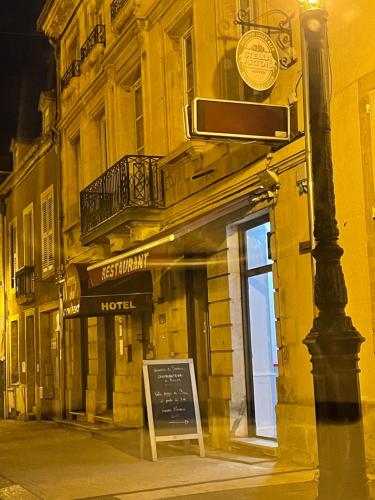 a building with a sign in front of a hotel at Hôtel du Commerce in Semur-en-Auxois