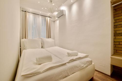 a white bed in a room with a window at Standard Apartment by Hi5 - Center of city center in Budapest