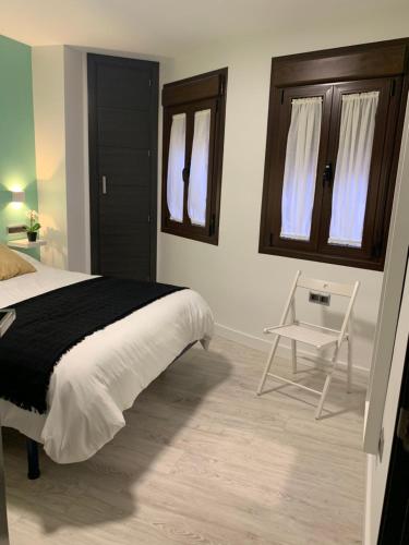a bedroom with a bed and a chair in it at APARTAMENTO LAS NIÑAS in Ronda