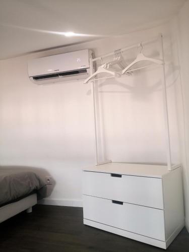 - une commode blanche dans une chambre avec un lit dans l'établissement Orange Théâtre Studio, à Orange