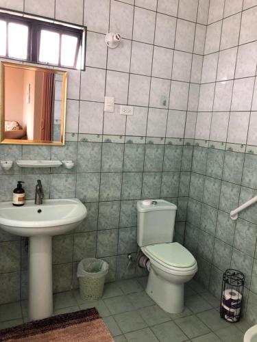 a bathroom with a toilet and a sink at The Bey Bed and Breakfast in El Socorro