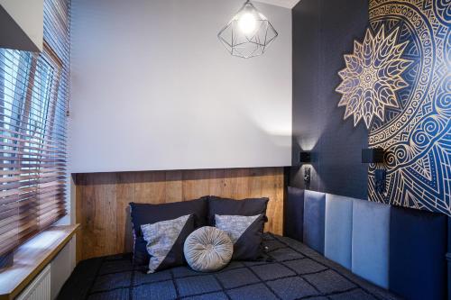 Habitación con sofá con almohadas y pared. en Apartament z jacuzzi w centrum Sanoka en Sanok