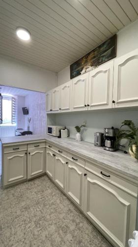 une cuisine avec des armoires blanches et un comptoir dans l'établissement appartement cosy - 2 chambres, situé en Centre Ville, à Nice