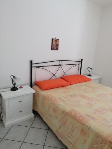 a bedroom with a bed with orange pillows on it at Villetta Lido Marini in Lido Marini