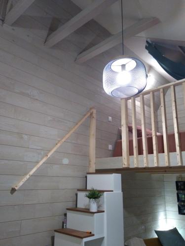 a room with a staircase and a pendant light at Le gîte du passage in Plougastel-Daoulas