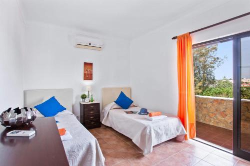 Cette chambre comprend 2 lits, une table et une fenêtre. dans l'établissement Villa Leoes by Villa Plus, à Carvoeiro