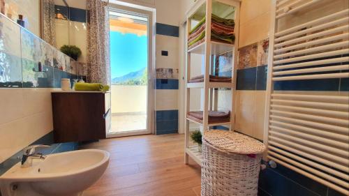 a bathroom with a sink and a mirror and a window at LUXURY VILLA SLEEP 6 CLOSE TO LAKE OF COMO in Traona