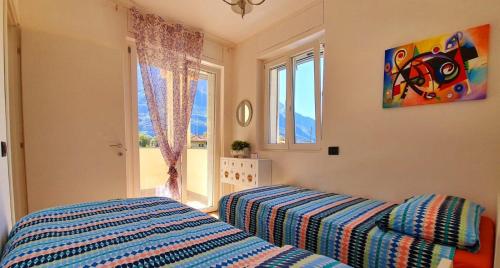 a bedroom with a bed and a window at LUXURY VILLA SLEEP 6 CLOSE TO LAKE OF COMO in Traona