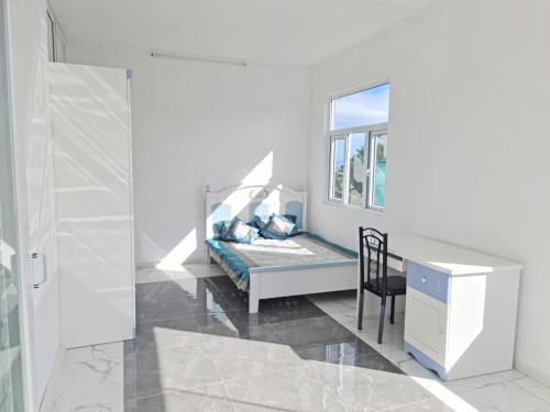 Réunion的住宿－Lovely brand new luxury 2-bedroom apartment in Vacoas, Mauritius，一间卧室配有一张床、一张桌子和一把椅子