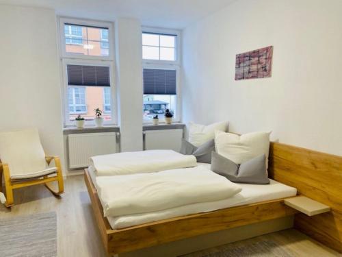 two beds in a room with two windows at City Hotel in Eisenach