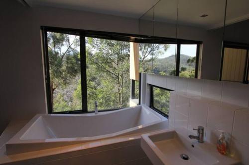a large bath tub in a bathroom with a large window at Luxurious, Tranquil and Private in Lindisfarne