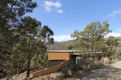 a house on a hill with trees in the background at Luxurious, Tranquil and Private in Lindisfarne