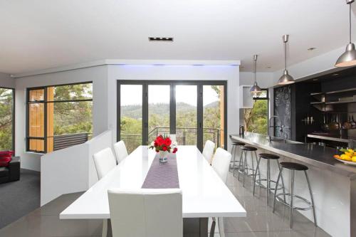 a kitchen with a white table and white chairs at Luxurious, Tranquil and Private in Lindisfarne