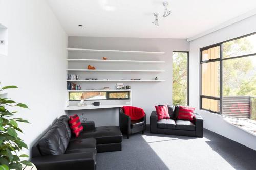 a living room with two black couches and red pillows at Luxurious, Tranquil and Private in Lindisfarne
